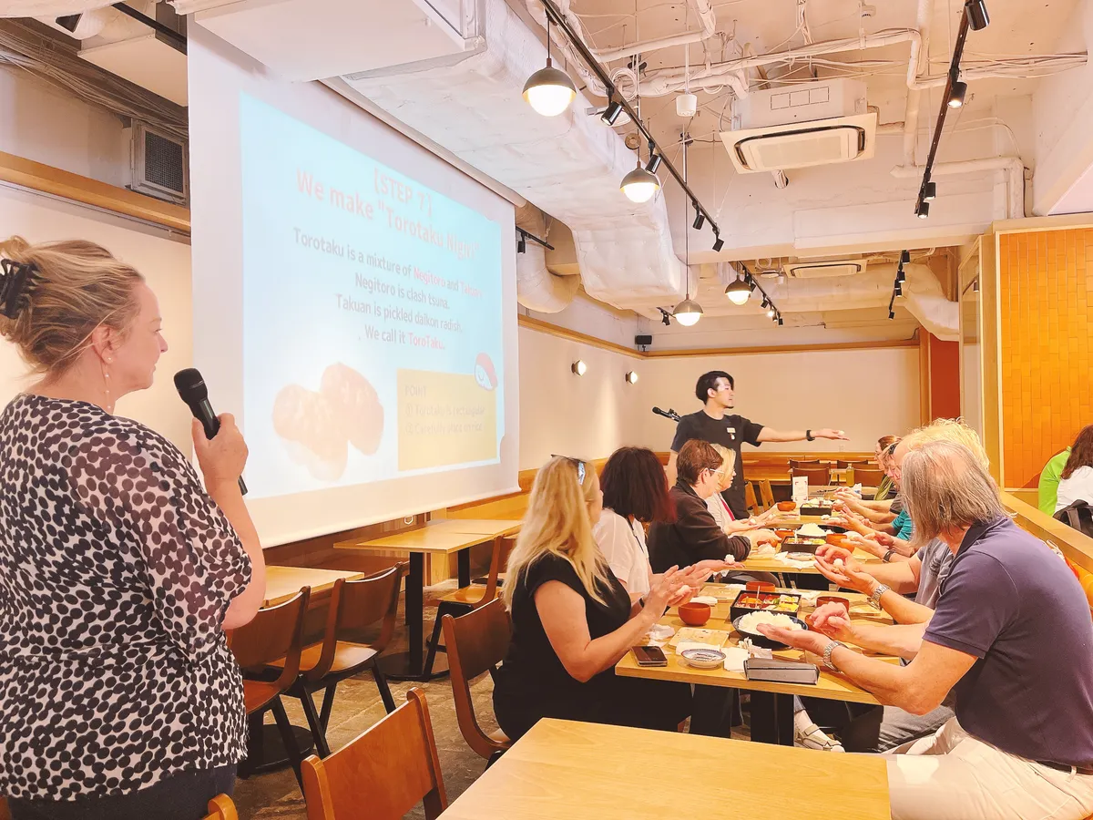 Participants making sushi with instructor support
